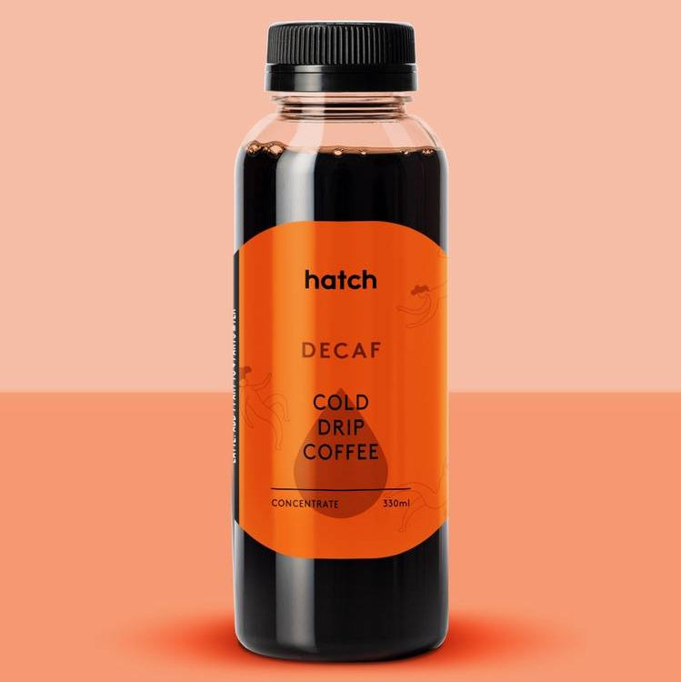 Bottle of hatch Decaf Cold Drip Coffee on a peach background