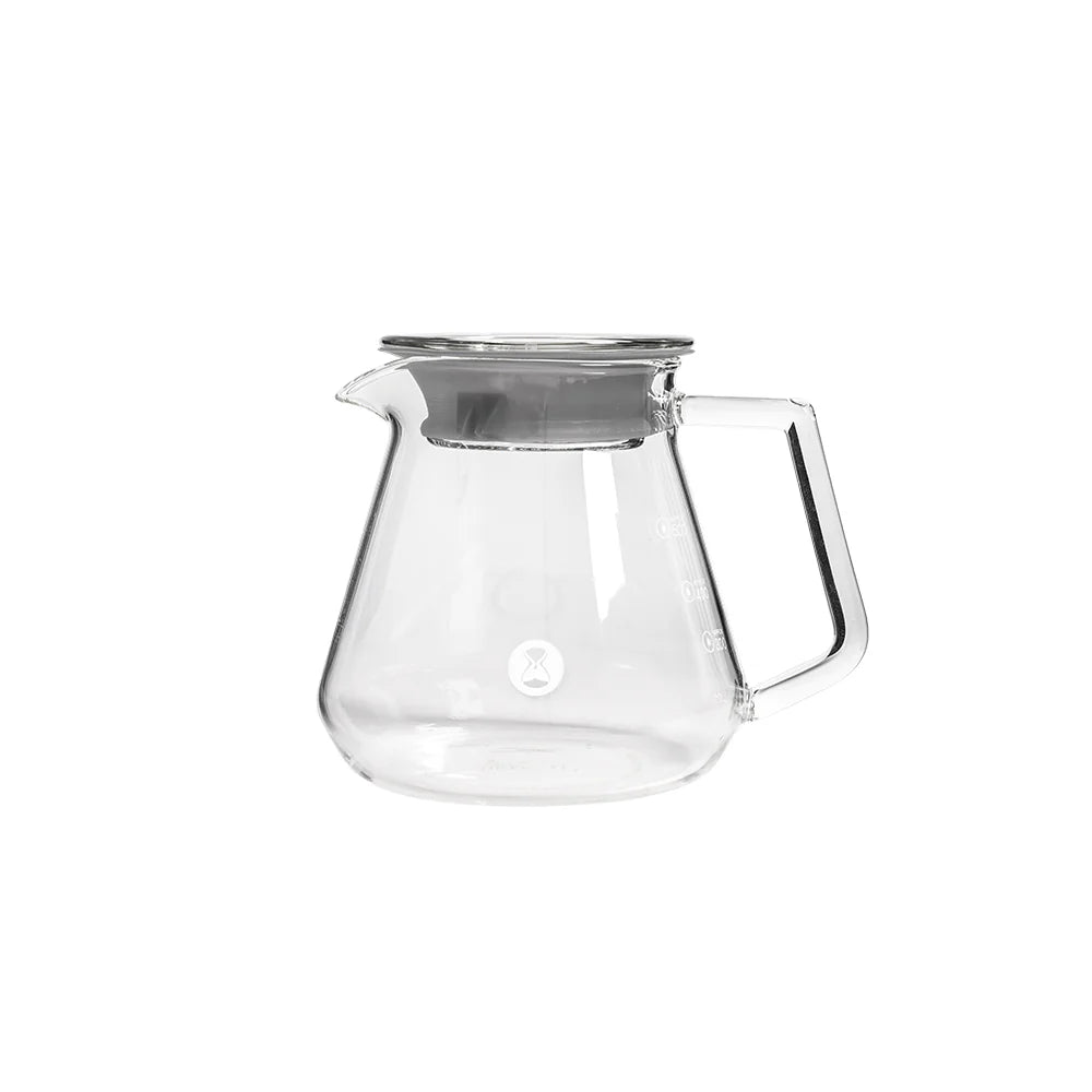Clear glass teapot with a silver lid on a white background