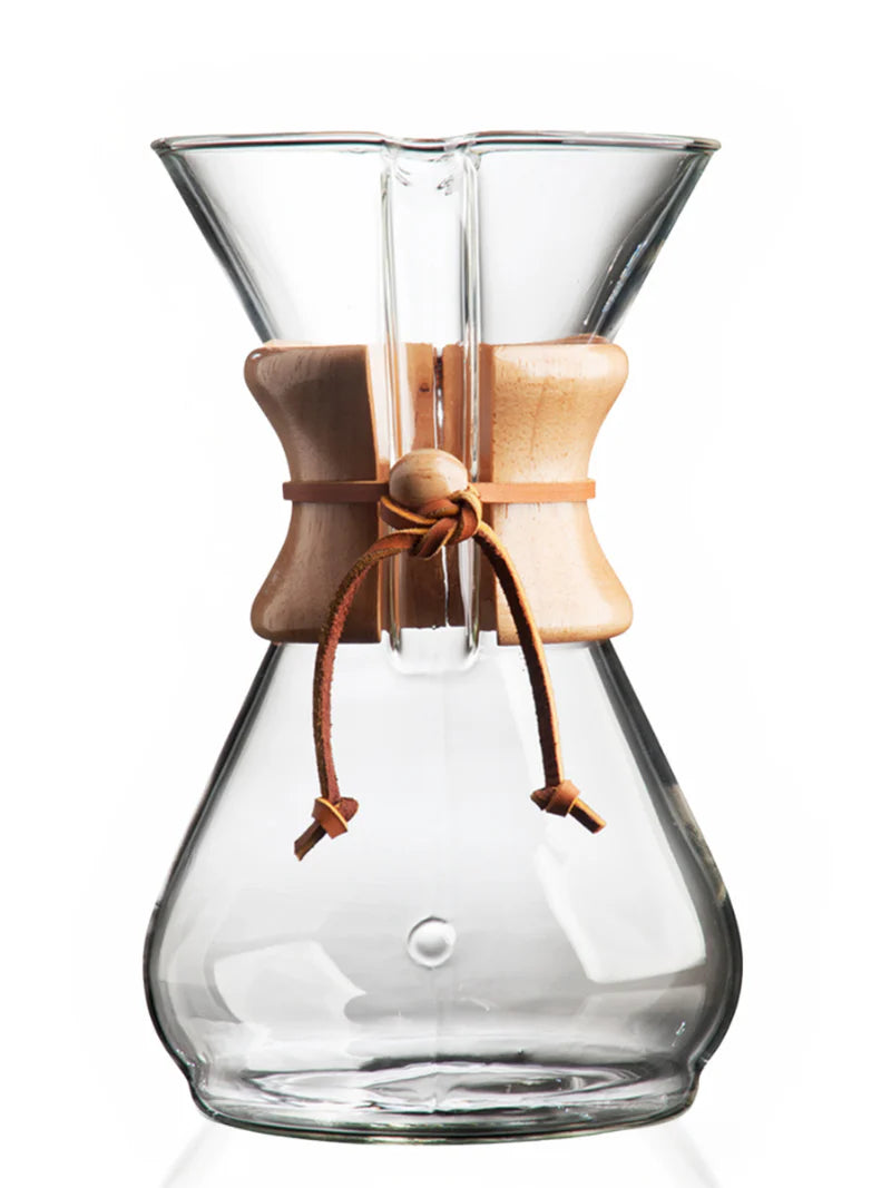Clear glass coffee maker with wooden collar and leather tie on a white background