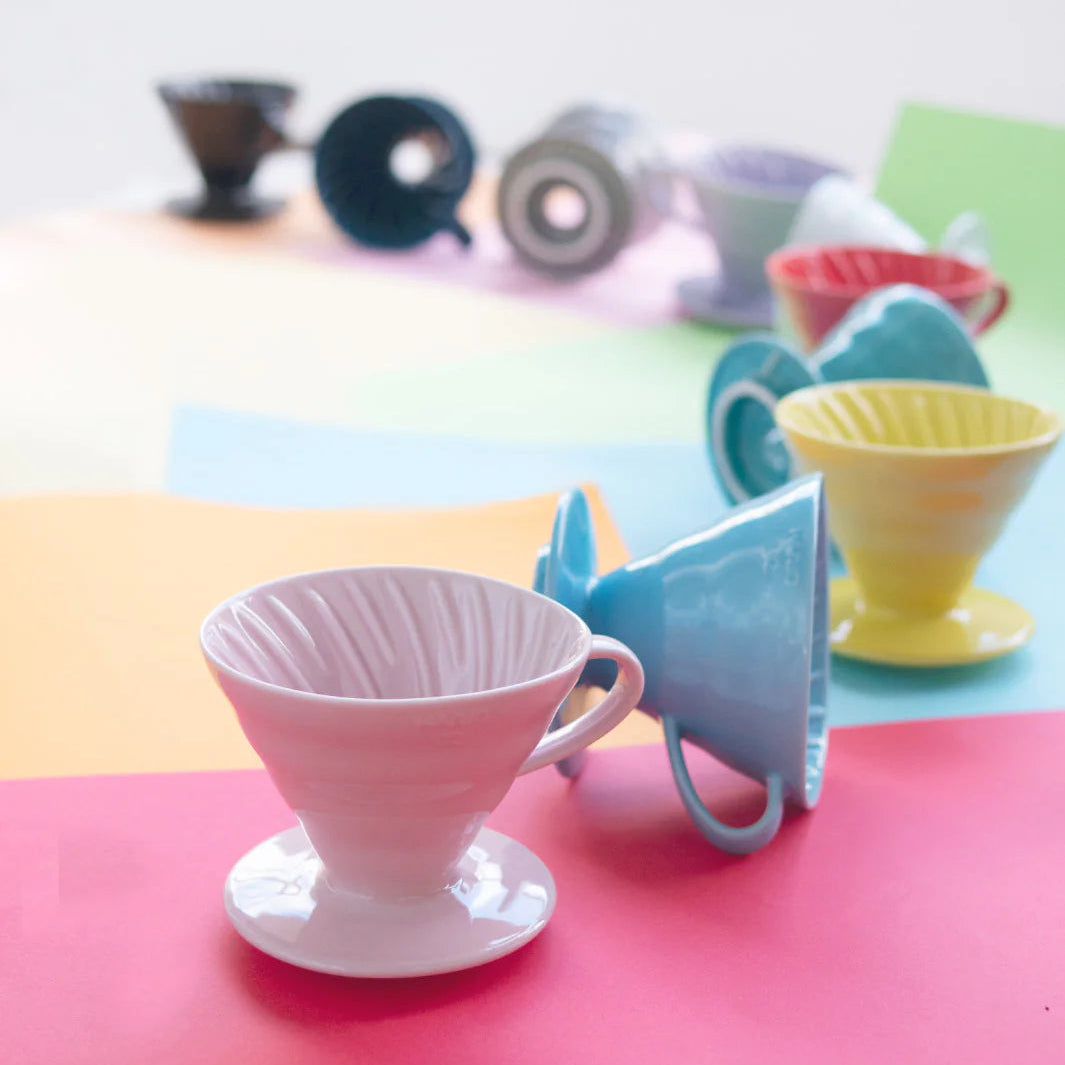 Colorful ceramic coffee drippers on a multicolored surface