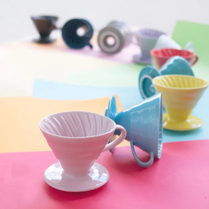 Colorful ceramic coffee drippers on a multicolored surface