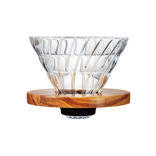 Clear glass coffee dripper on a wooden stand against a white background