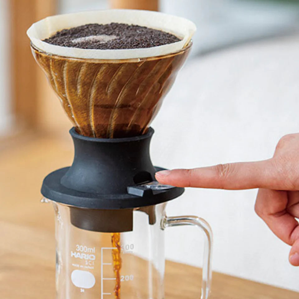 Coffee brewing process using a pour-over coffee maker on a wooden surface.