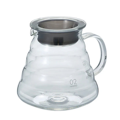 Clear glass coffee server with metal lid on a white background